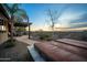 Outdoor space with a hot tub, seating area, and lovely desert views at sunset at 35322 N 27Th Ln, Phoenix, AZ 85086