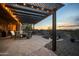 Outdoor patio with a fire pit and desert views, offering a serene setting with string lights on pergola at 35322 N 27Th Ln, Phoenix, AZ 85086