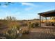 Expansive backyard with desert landscaping, a covered patio, and stunning views of the surrounding desert landscape at 35322 N 27Th Ln, Phoenix, AZ 85086