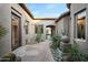 Inviting courtyard with stone pathway, desert plants and a fountain create a tranquil and welcoming entrance at 35322 N 27Th Ln, Phoenix, AZ 85086