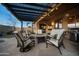 Covered patio with comfortable seating around a fire pit and built-in BBQ, ideal for outdoor living at 35322 N 27Th Ln, Phoenix, AZ 85086