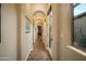 Elegant hallway with arched doorways, tile flooring, and natural light from the side window at 35322 N 27Th Ln, Phoenix, AZ 85086