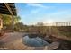 Backyard hot tub with stone surround, a waterfall feature, and desert landscaping creates a serene outdoor oasis at 35322 N 27Th Ln, Phoenix, AZ 85086