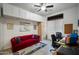 Bright office featuring a red sofa, ceiling fan, built-in cabinets, and an open workspace at 35322 N 27Th Ln, Phoenix, AZ 85086