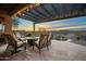 Cozy covered patio features stone flooring, an outdoor firepit and desert views for ultimate relaxation at 35322 N 27Th Ln, Phoenix, AZ 85086