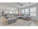 Spacious living room featuring a large sectional couch, stylish rug, and seamless flow into the kitchen and dining area at 3533 E Harwell Rd, Gilbert, AZ 85234