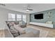 Comfortable living room with a large sectional couch, modern TV wall with shelving, and natural light from the windows at 3533 E Harwell Rd, Gilbert, AZ 85234