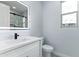 Bright bathroom with a modern sink, illuminated mirror, toilet and view of the shower and an exterior window at 3623 S 78Th Dr, Phoenix, AZ 85043