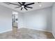 Modern bedroom with tiled floors, ceiling fan, and a glimpse into a stylish bathroom at 3623 S 78Th Dr, Phoenix, AZ 85043