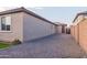 Gravel side yard of a tan home with a light brown roof and a view of other houses at 3623 S 78Th Dr, Phoenix, AZ 85043