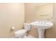 A well-lit powder room features a pedestal sink, toilet and a decorative mirror at 3751 S Vista Pl, Chandler, AZ 85248