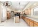 Bright kitchen with tile floors, island with sink, wood cabinets, and view to living room at 3751 S Vista Pl, Chandler, AZ 85248