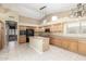 Bright kitchen with tile floors, island with sink, wood cabinets, and black appliances for a clean design at 3751 S Vista Pl, Chandler, AZ 85248