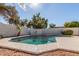 A private backyard pool with clear water and surrounded by stone and a white wall with artistic features at 3751 S Vista Pl, Chandler, AZ 85248