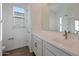 Clean, bright bathroom featuring white cabinets, countertop, and a large mirror above the sink at 4083 W Eli Dr, San Tan Valley, AZ 85144