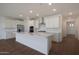 Spacious kitchen features white cabinets, stainless steel appliances, and an island with a quartz countertop at 4083 W Eli Dr, San Tan Valley, AZ 85144