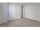 Simple bedroom with light carpet, white walls, closet with sliding doors and paneled door at 4093 W Eli Dr, San Tan Valley, AZ 85144