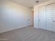 Cozy bedroom featuring plush carpet, white walls, closet, and a white paneled door at 4093 W Eli Dr, San Tan Valley, AZ 85144