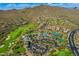 Breathtaking aerial of a luxury community featuring a golf course, mountains, and desert landscaping at 41012 N Noble Hawk Way, Anthem, AZ 85086