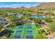 Aerial view of community tennis and pickleball courts and resort-style pool and surrounding desert landscape at 41012 N Noble Hawk Way, Anthem, AZ 85086