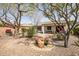 Spacious backyard with a covered patio, lush greenery, and a gravel landscape at 41012 N Noble Hawk Way, Anthem, AZ 85086