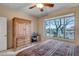 Bedroom featuring armoire, desk and a large window overlooking the landscaped backyard at 41012 N Noble Hawk Way, Anthem, AZ 85086