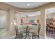 Stylish dining area with a glass table and view into the cozy living room at 41012 N Noble Hawk Way, Anthem, AZ 85086