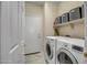 Bright laundry room with a modern washer and dryer and ample storage on a shelf at 41012 N Noble Hawk Way, Anthem, AZ 85086