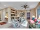 Inviting living room with a ceiling fan, fireplace, built in shelving, and plenty of natural light at 41012 N Noble Hawk Way, Anthem, AZ 85086