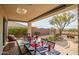 Elegant outdoor patio with a dining table set for a meal and landscaped backyard at 41012 N Noble Hawk Way, Anthem, AZ 85086