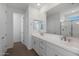 Bright bathroom with double vanity, white countertops, modern fixtures, and a large mirror at 4107 W Eli Dr, San Tan Valley, AZ 85144