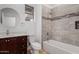 Bathroom featuring dark cabinets, modern tub and shower, and round mirror at 41401 N Maidstone Ct, Anthem, AZ 85086