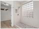 Modern bathroom shower features white tile, glass block window and pebble floor at 41401 N Maidstone Ct, Anthem, AZ 85086