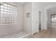 Bright bathroom featuring white tile shower with glass block and view to the outside at 41401 N Maidstone Ct, Anthem, AZ 85086