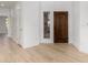 Bright entryway featuring light wood floors, white walls, and a solid wood front door at 41401 N Maidstone Ct, Anthem, AZ 85086