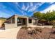 Back exterior of home featuring covered patio, desert landscaping and outdoor dining space at 41401 N Maidstone Ct, Anthem, AZ 85086