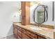 Bathroom featuring granite countertops, dual sinks, a vanity, a framed mirror, and a shower at 4226 E Jojoba Rd, Phoenix, AZ 85044