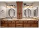 Bathroom vanity with granite countertops, dual sinks, lighting, and dark wood cabinets at 4226 E Jojoba Rd, Phoenix, AZ 85044