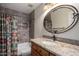 Bathroom featuring a granite countertop, oval mirror, and tiled shower and bath at 4226 E Jojoba Rd, Phoenix, AZ 85044