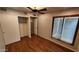 Bright bedroom with wood floors features a ceiling fan and closet with sliding doors at 4226 E Jojoba Rd, Phoenix, AZ 85044