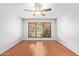 A spacious bedroom with wood floors, a ceiling fan, and a window with wood blinds at 4226 E Jojoba Rd, Phoenix, AZ 85044