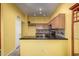 Stylish kitchen featuring black countertops, wooden cabinets, and modern fixtures at 4226 E Jojoba Rd, Phoenix, AZ 85044