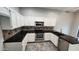 Updated kitchen with white cabinets, black counters, and stainless steel appliances at 4226 E Jojoba Rd, Phoenix, AZ 85044