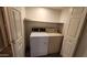 Well lit laundry room contains a washer, dryer, and shelving for storage at 4226 E Jojoba Rd, Phoenix, AZ 85044
