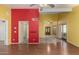 Bright living room with hardwood floors, ceiling fan, and red accent wall at 4226 E Jojoba Rd, Phoenix, AZ 85044