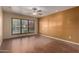 Inviting living room featuring wood floors, a ceiling fan, and a large window at 4226 E Jojoba Rd, Phoenix, AZ 85044