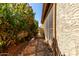 Side yard with a gravel path and desert landscaping, surrounded by stucco walls at 4226 E Jojoba Rd, Phoenix, AZ 85044