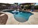 Backyard pool area featuring a covered patio, fire pit, and lush landscaping at 4312 W Olney Ave, Laveen, AZ 85339