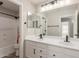 Bathroom featuring double sinks, white quartz countertop, decorative mirror, and a shower tub combo at 43554 W Sunland Dr, Maricopa, AZ 85138