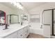 Bright bathroom with double sinks, black hardware, white quartz countertop, bathtub and black framed shower at 43554 W Sunland Dr, Maricopa, AZ 85138